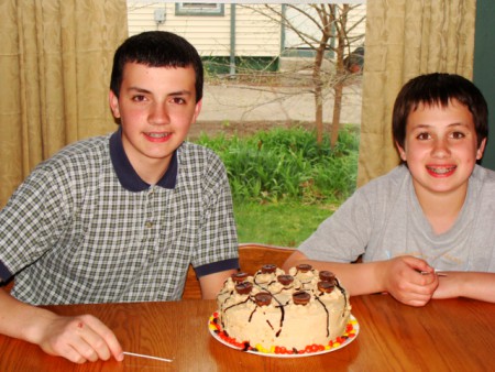 An inside out peanut butter cup cake. It is a homemade chocolate cake with homemade peanut butter frosting with chocolate sauce drizzled on top. It is Stephen's 15th and Matthew's 13th birthday.